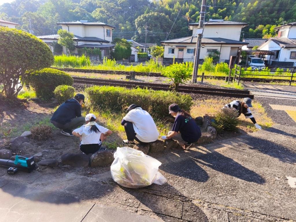 駅の花壇で草取りをする様子